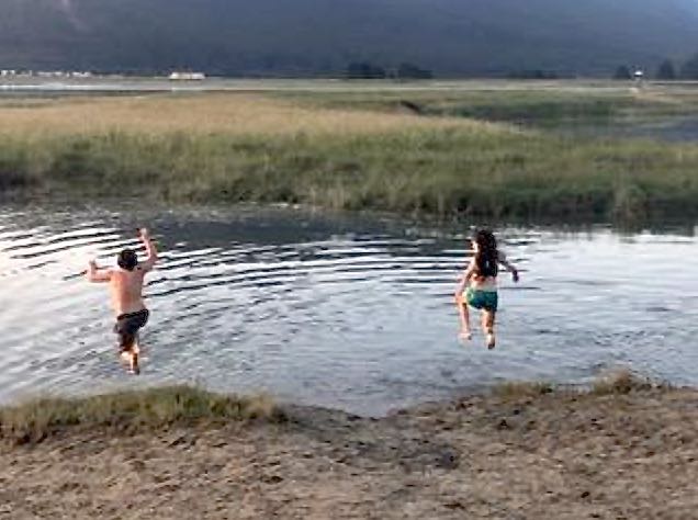 Photo of two kids jumping into the water